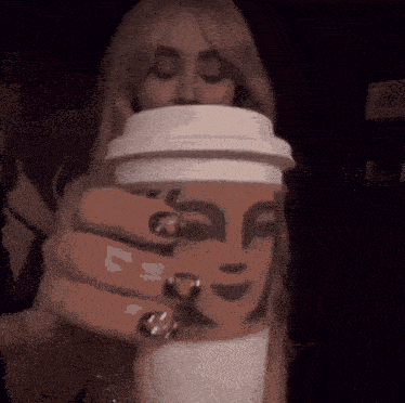a woman is holding a cup of coffee in her hands