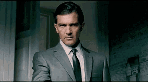 a man in a suit and tie is standing in front of a door .