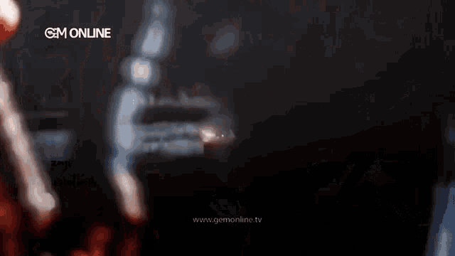 a blurry image of a person playing a guitar with the words gem online in the upper right corner