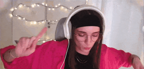 a woman wearing headphones and glasses is making a funny face .
