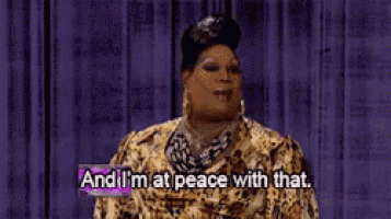 a woman is standing in front of a purple curtain and saying and i 'm at peace with that .