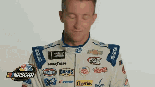 a man is wearing a nascar uniform with many logos on it .