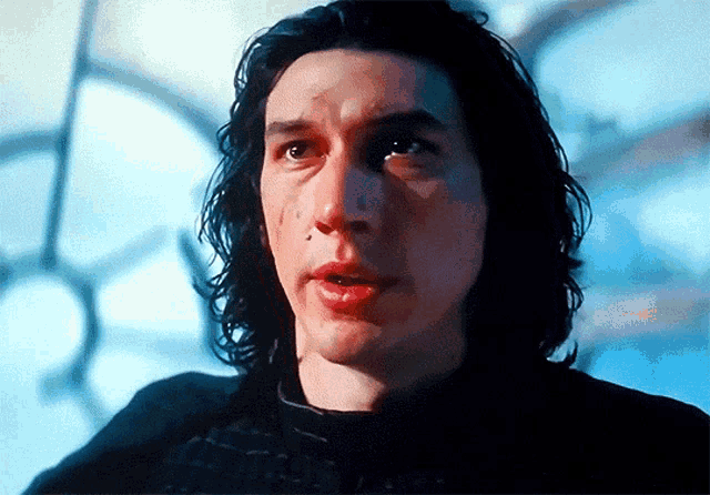 a close up of a man 's face with long hair