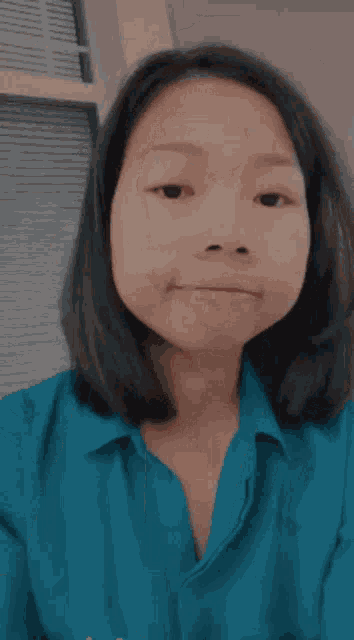 a woman wearing a blue shirt with the letter n on the pocket