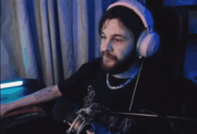 a man is wearing headphones and looking at his phone
