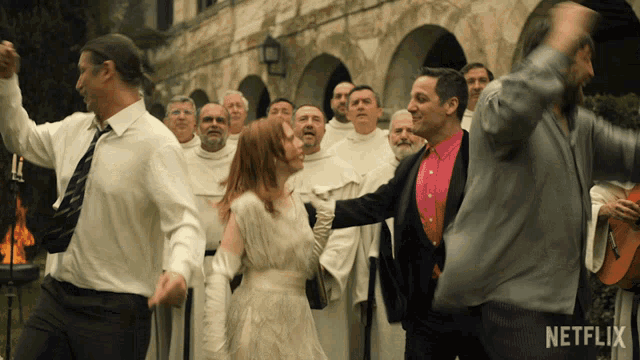 a group of people are dancing in front of a building with a netflix logo on the bottom