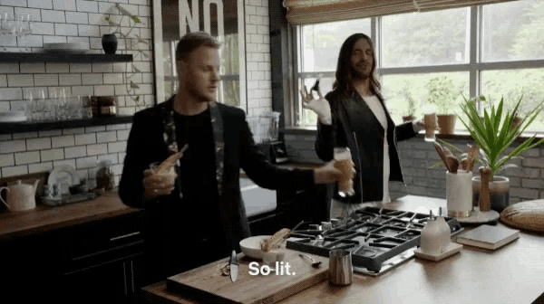 two men standing in a kitchen with the word so lit on the counter