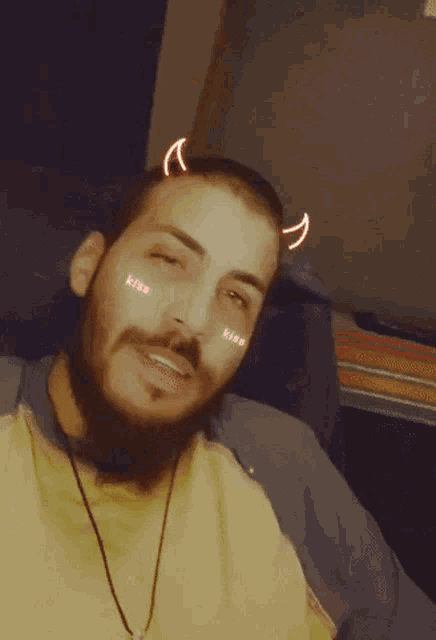 a man with braces on his teeth is making a devil horns gesture