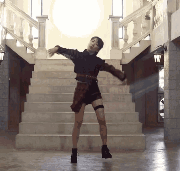 a woman in a plaid skirt is dancing on stairs