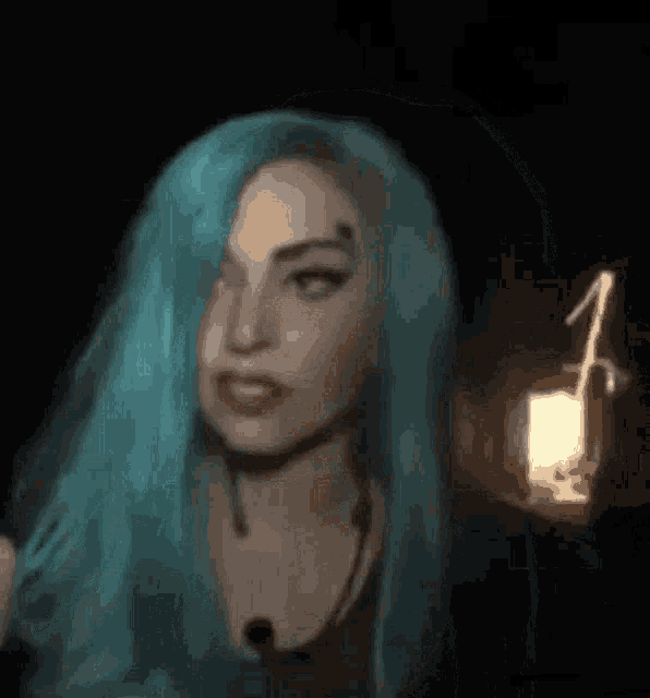 lady gaga with blue hair is holding a light in her hand