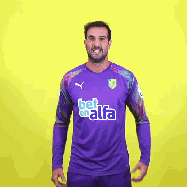 a man wearing a purple bet on alfa jersey