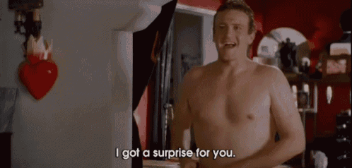 a shirtless man is standing in a room and saying i got a surprise for you