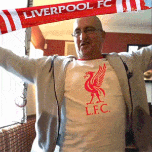 a man wearing a liverpool fc shirt and scarf