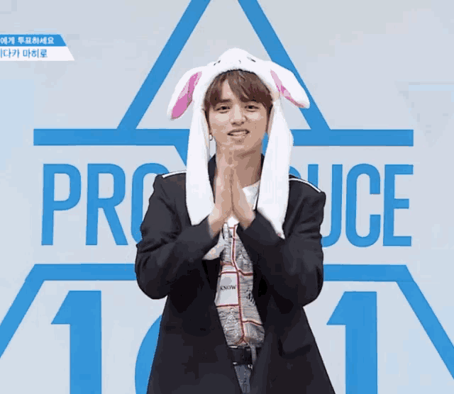a man wearing bunny ears stands in front of the number 1