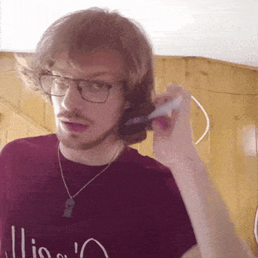 a man wearing glasses and a red shirt that says ' illio ' on it
