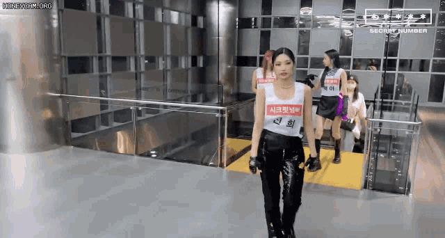 a group of women are walking down a staircase in a building .