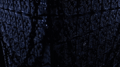 a lightning bolt is hitting a cube hanging from chains .