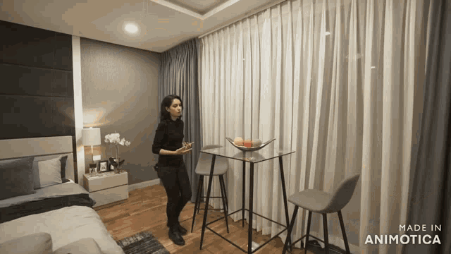 a woman is standing in a bedroom with the words made in animatica on the bottom