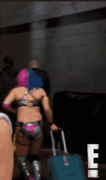 a woman in a bikini is pulling a suitcase with the letter e in the lower right corner