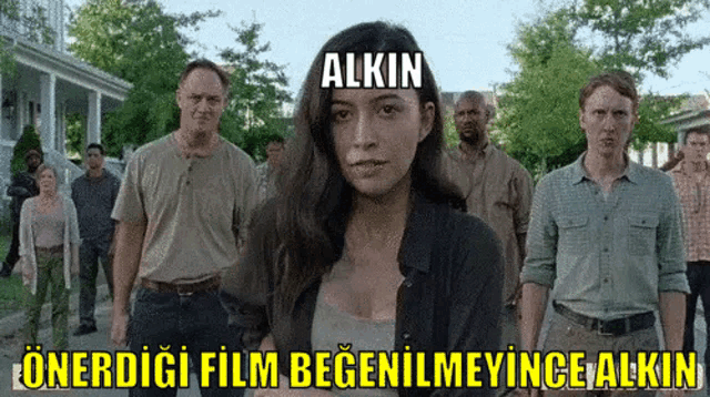 a group of people are standing in front of a sign that says " alkin "