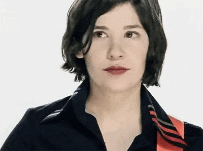 a woman with short hair and red lips is wearing a black shirt and a red tie .