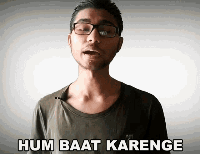 a man wearing glasses says " hum baat karenge "