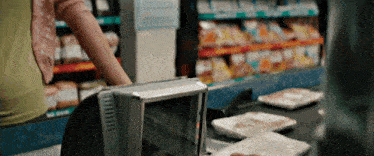 a woman is standing at a counter in a store