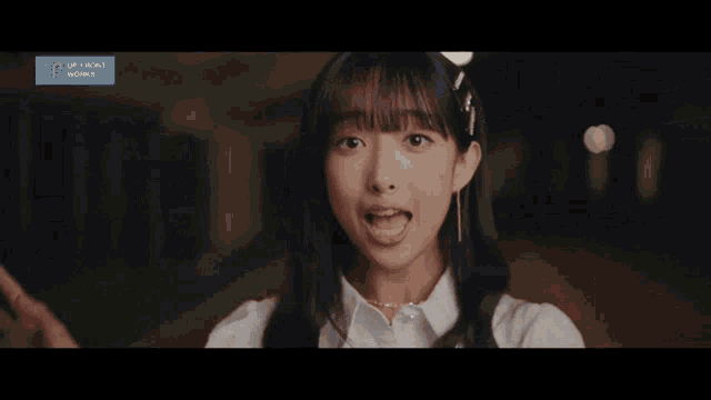 a girl is making a funny face in front of a sign that says upfront world