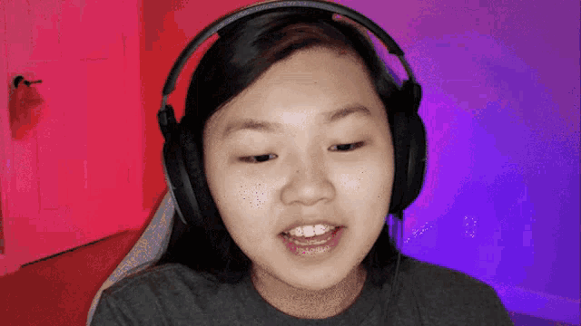 a girl wearing headphones looks at the camera and smiles