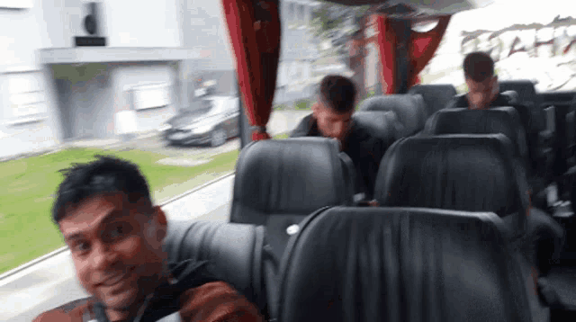 a man sitting on a bus with a backpack on