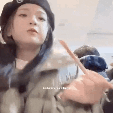 a woman wearing a beret is holding a stick in her hand while sitting on a plane .