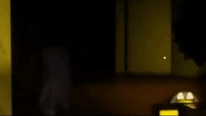 a cartoon character is walking in a dark room .