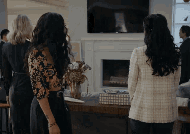 a group of women standing in front of a television