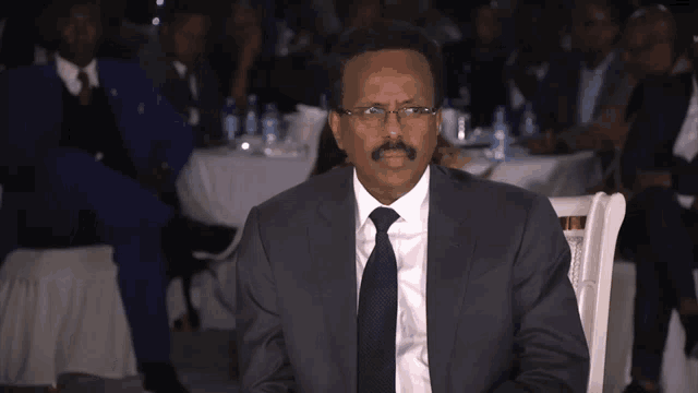 a man in a suit and tie sitting in a chair