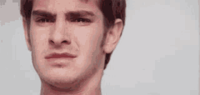 a close up of a man 's face with a crying look on his face .