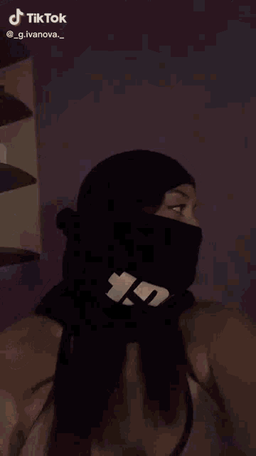 a woman wearing a black beanie and headphones is making a funny face .