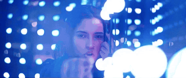 a woman is standing in front of a display of blue lights