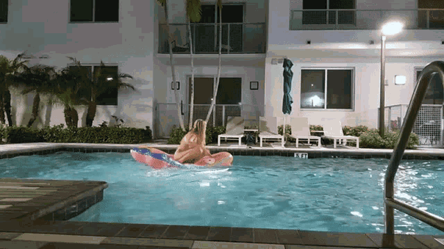 a woman is floating on a pink raft in a swimming pool with the letters ktr on the side