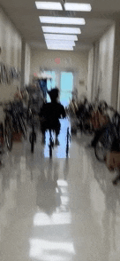 a blurred image of a person in a wheelchair in a hospital hallway .