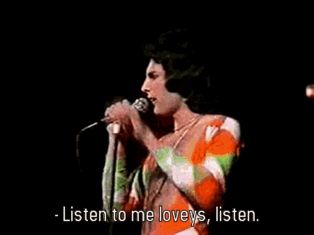 a man singing into a microphone with the words listen to me loveys