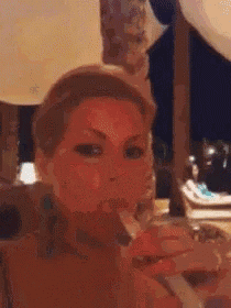 a woman is smoking a cigarette in front of a table with balloons .