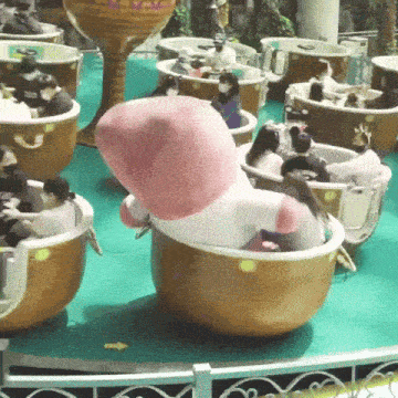 a group of people are riding a teacup ride at an amusement park