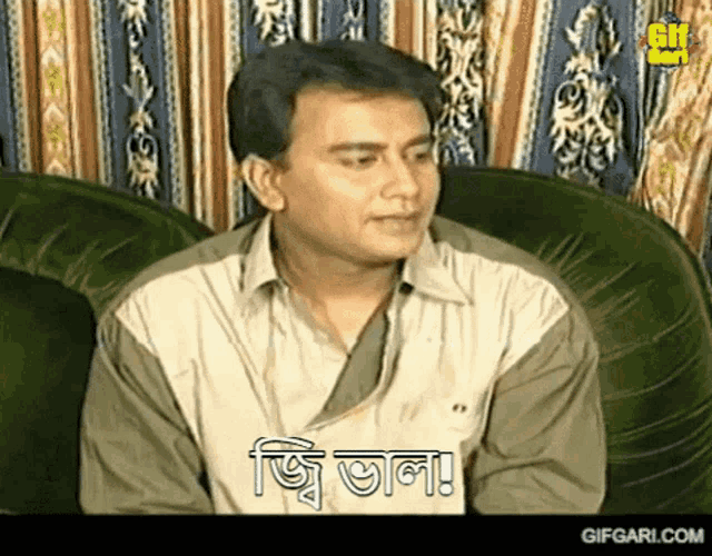 a man is sitting on a green couch with a gif from gifgari.com