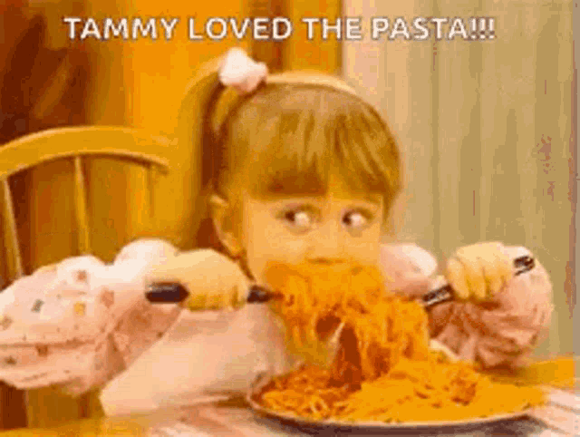 a little girl is eating a large plate of spaghetti with a fork and knife .