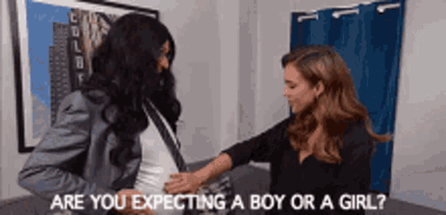 a woman is touching a pregnant woman 's belly with the words are you expecting a boy or a girl