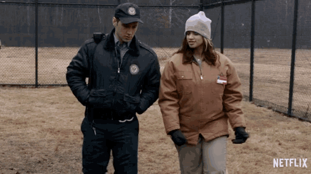 a man and a woman standing next to each other with a netflix logo in the background