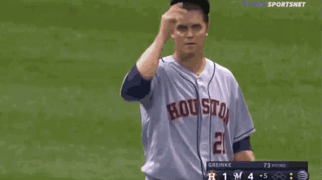 a baseball player wearing a houston jersey stands on the field