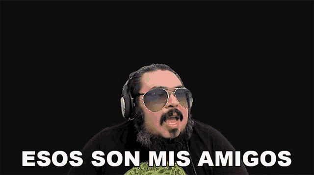 a man wearing sunglasses and headphones is saying esos son mis amigos