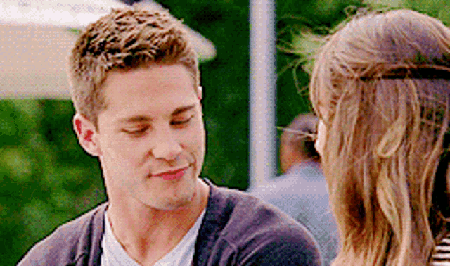 a man and a woman are looking at each other and talking .