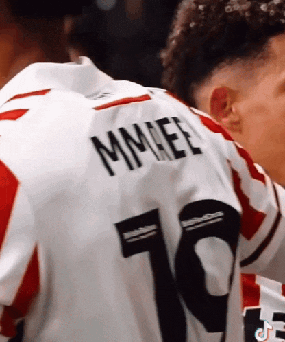 a soccer player wearing a white jersey with the name mmeel on the back